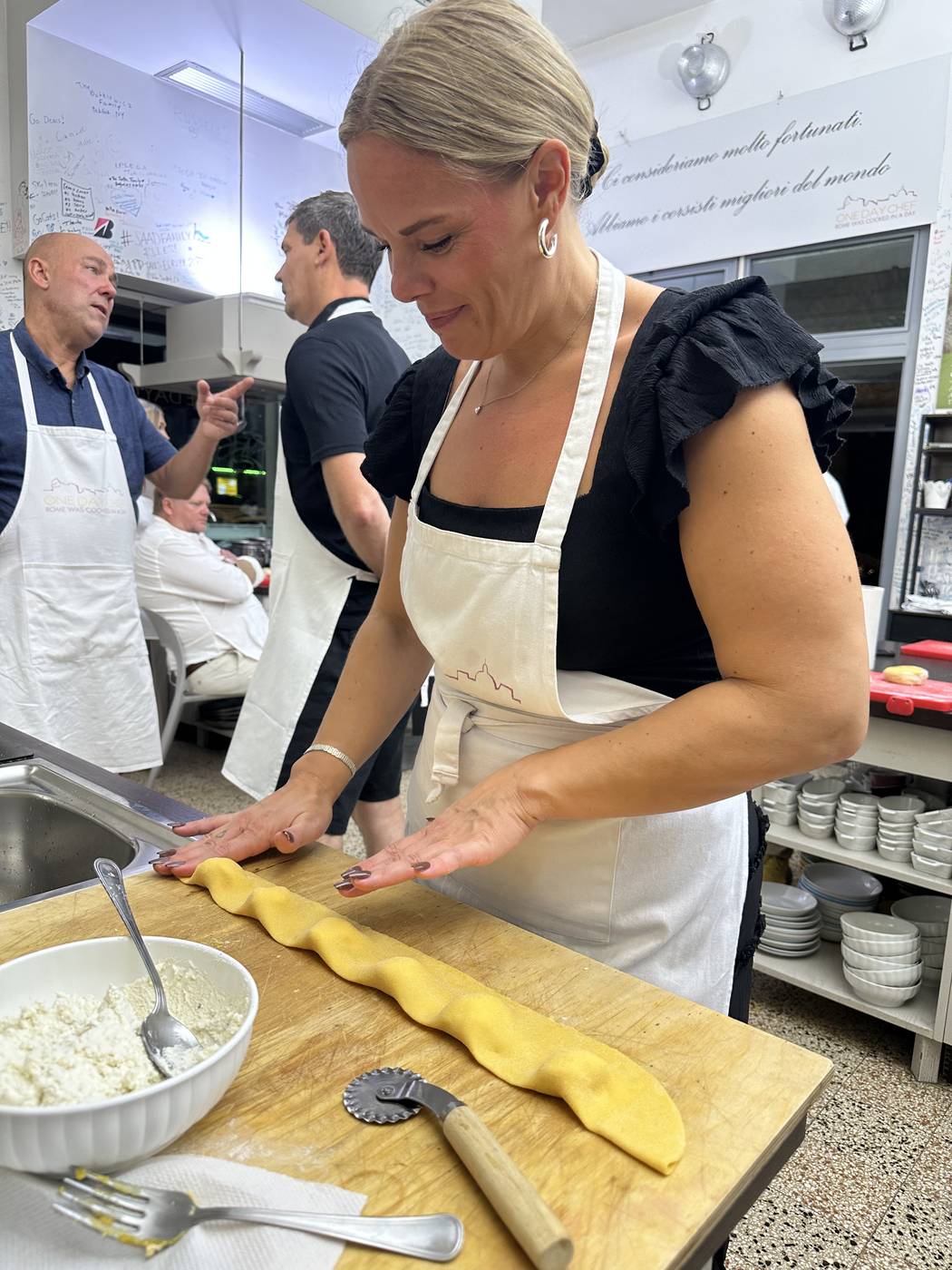 Partecipante che chiude a mano i ravioli ricotta e limone durante un corso di pasta fresca a Roma